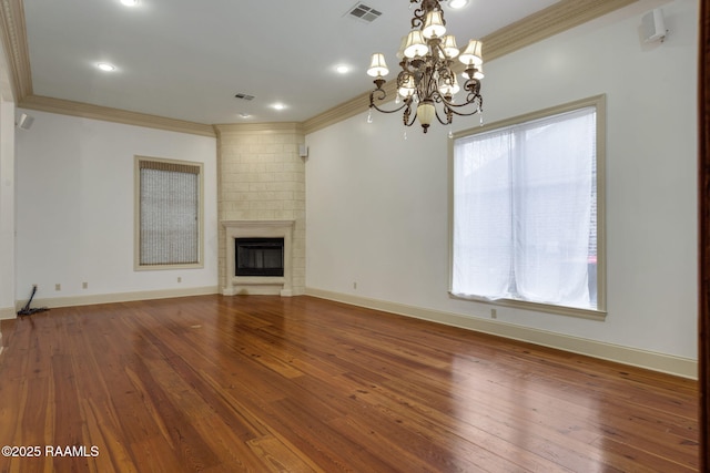 unfurnished living room featuring visible vents, a large fireplace, wood-type flooring, crown molding, and baseboards