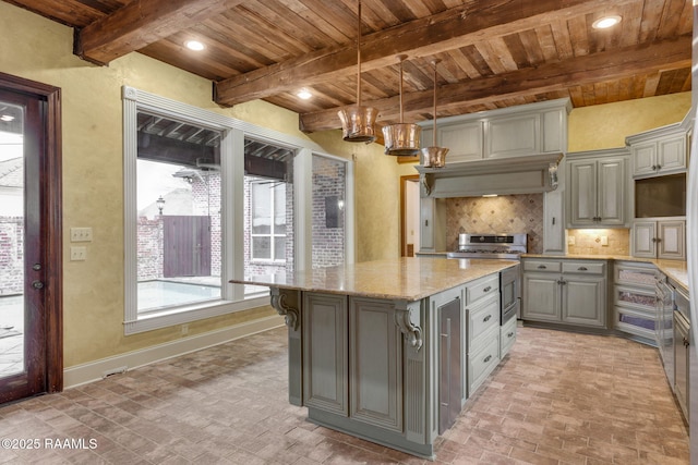 kitchen featuring tasteful backsplash, gray cabinetry, baseboards, brick floor, and stainless steel range