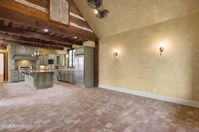 kitchen featuring gray cabinetry, baseboards, beamed ceiling, a kitchen bar, and appliances with stainless steel finishes