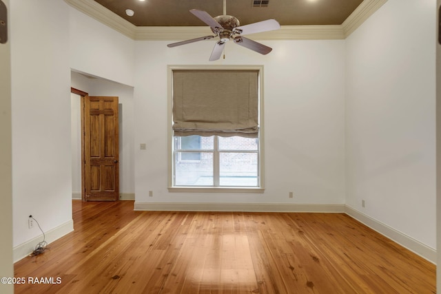 unfurnished room with visible vents, light wood-style flooring, a ceiling fan, crown molding, and baseboards