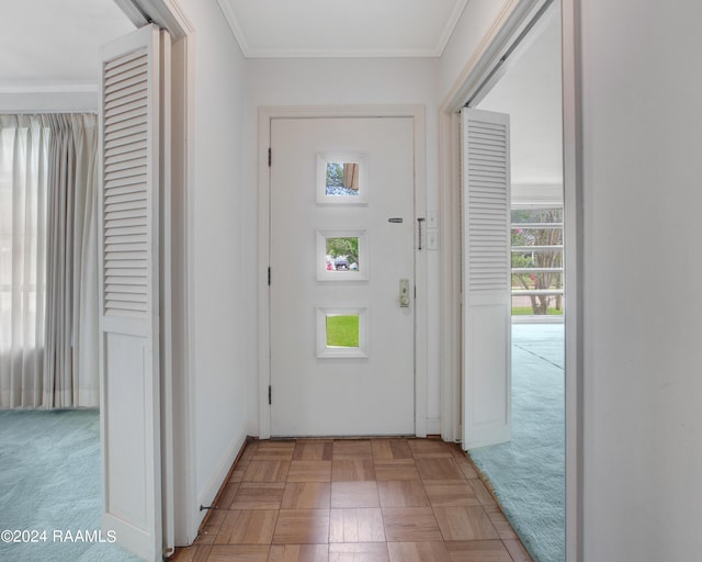 doorway with ornamental molding and light parquet flooring