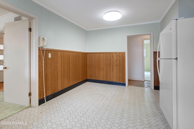 spare room featuring crown molding and wooden walls