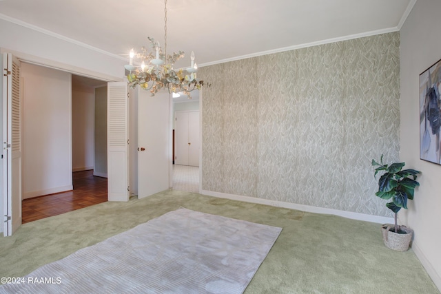 spare room featuring ornamental molding, a notable chandelier, and carpet flooring