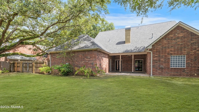 rear view of property featuring a patio and a lawn