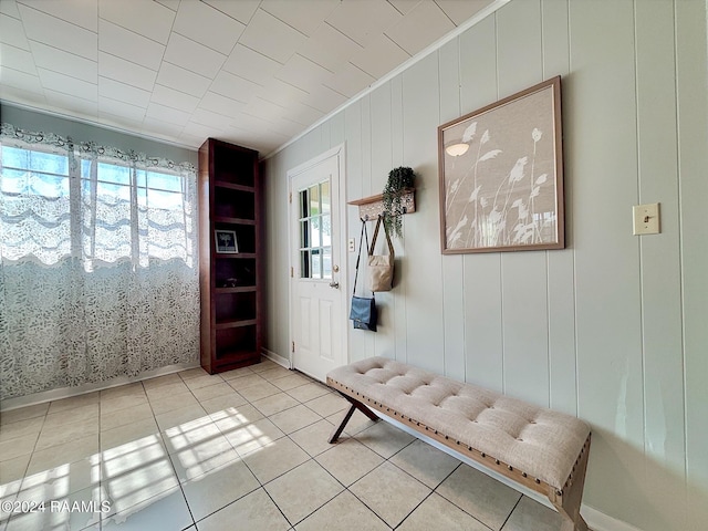 interior space with light tile patterned floors and ornamental molding