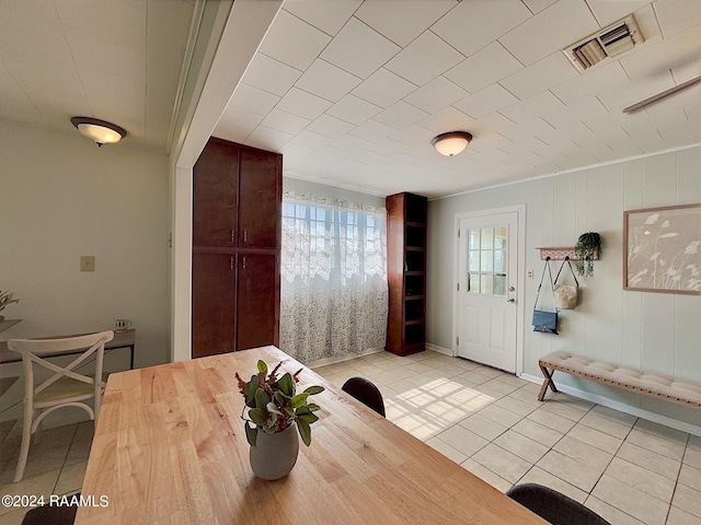 dining room with light tile patterned floors and ornamental molding