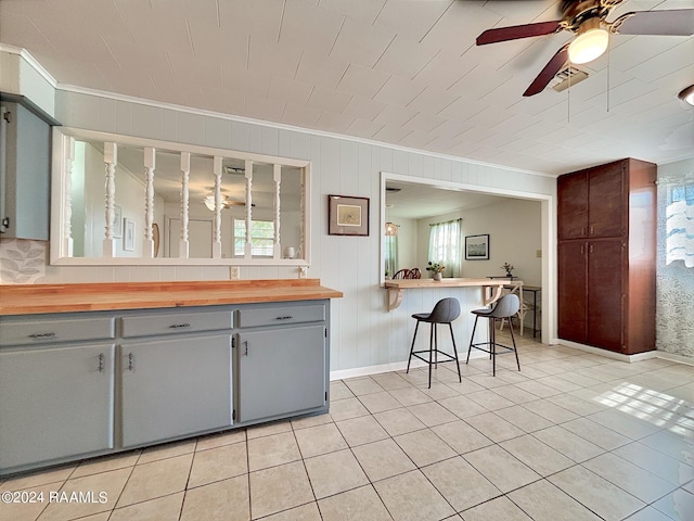 kitchen with gray cabinets, butcher block counters, and a breakfast bar area