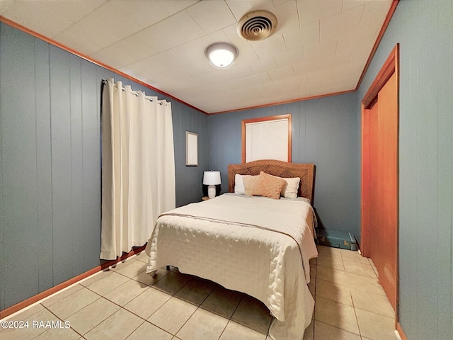 bedroom featuring light tile patterned floors and ornamental molding