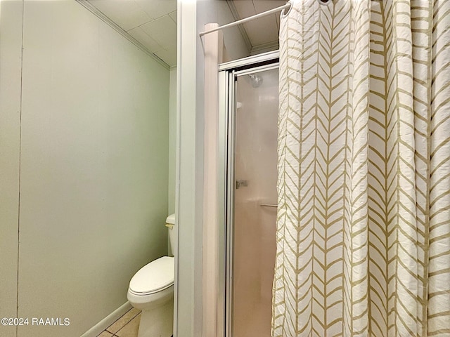 bathroom with tile patterned floors, a shower with door, and toilet