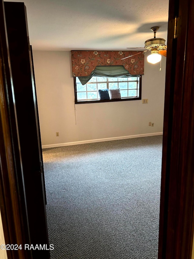 empty room with ceiling fan and carpet flooring