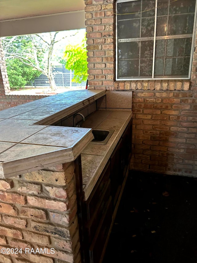 exterior space with sink and brick wall