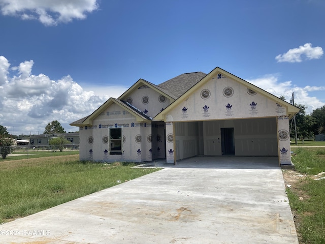 property under construction with a garage and a front lawn