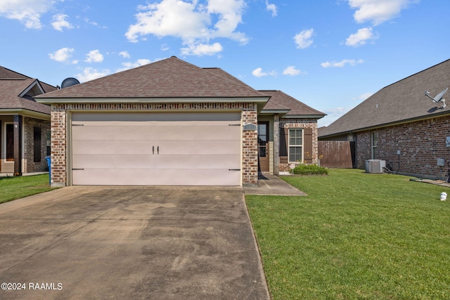 view of front of property with central AC, a garage, and a front yard