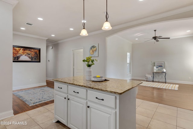 kitchen featuring hanging light fixtures, a kitchen island, light tile patterned floors, and white cabinets