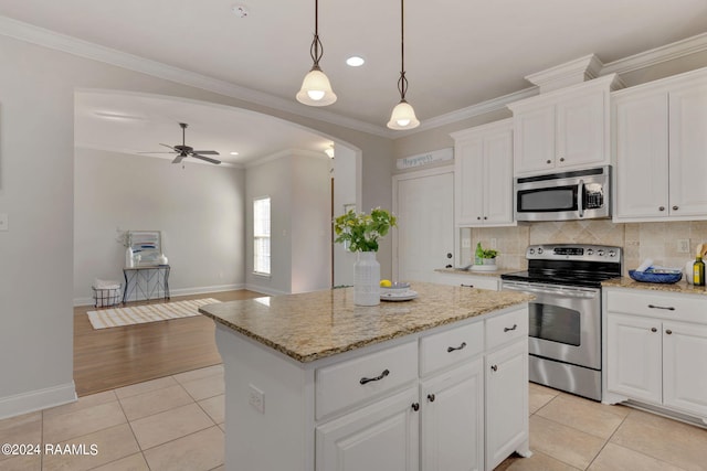 kitchen featuring light tile patterned flooring, white cabinetry, a center island, hanging light fixtures, and appliances with stainless steel finishes