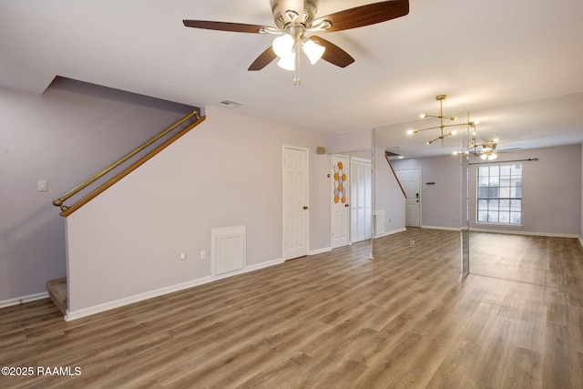 unfurnished living room with wood-type flooring and ceiling fan with notable chandelier