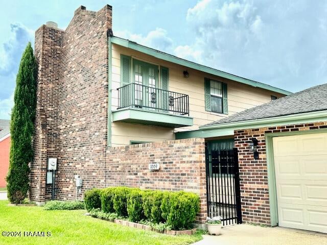 view of front of home with a garage and a balcony