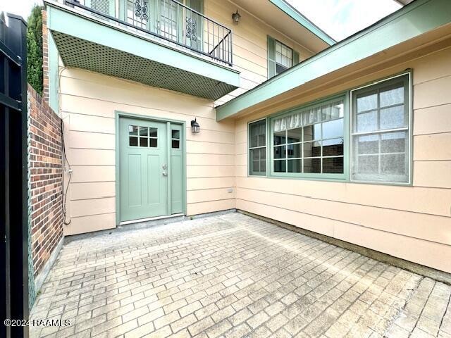 view of exterior entry featuring a balcony