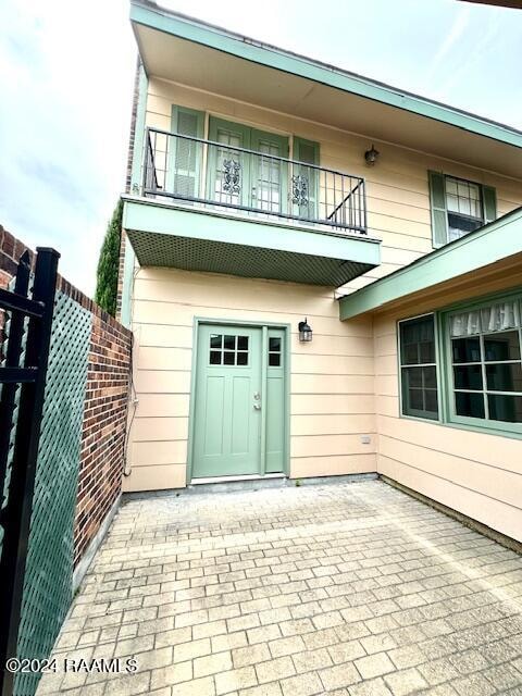 view of exterior entry featuring a balcony