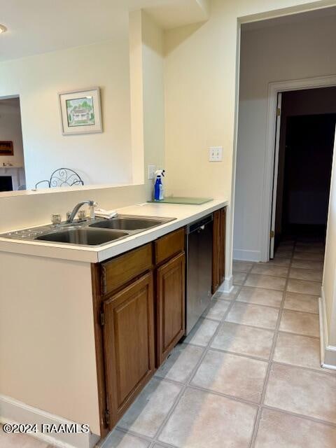 kitchen featuring light tile patterned flooring, dishwasher, and sink