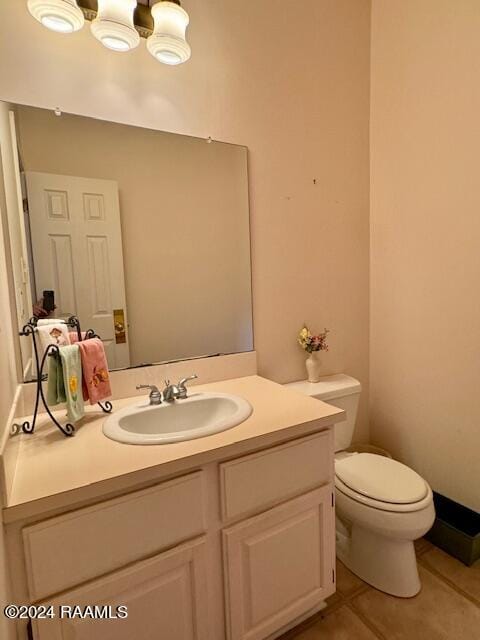 bathroom featuring vanity, tile patterned flooring, and toilet