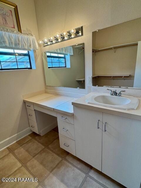 bathroom with tile patterned flooring, vanity, and plenty of natural light