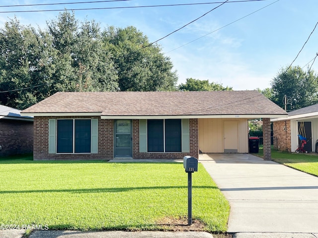 ranch-style home featuring a front lawn and a carport