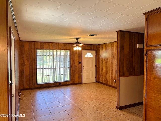 tiled empty room with wood walls and ceiling fan