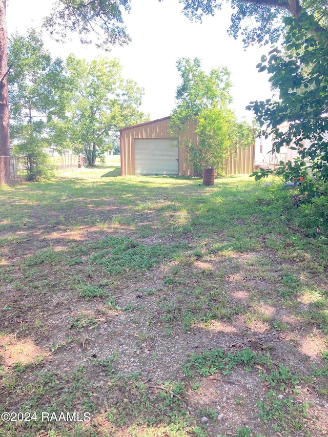 view of yard featuring a garage and an outbuilding