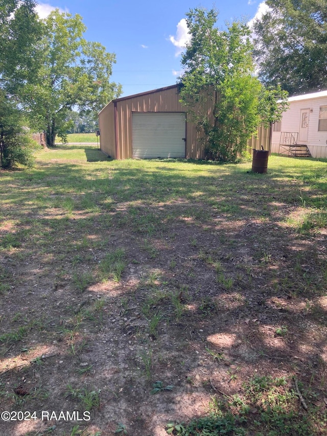 view of yard with a garage and an outdoor structure