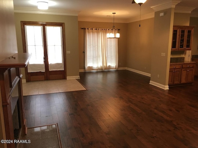 interior space with dark wood-type flooring, ornamental molding, and french doors