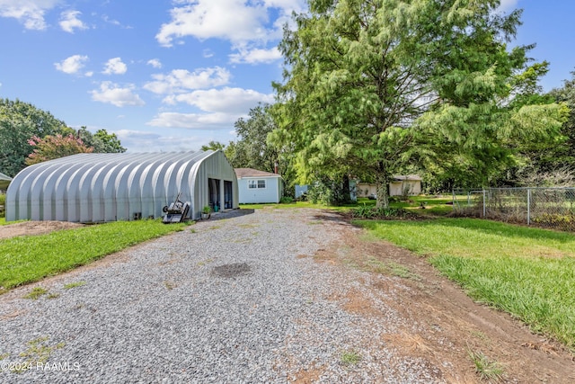 view of front of house featuring an outdoor structure, a garage, and a front yard