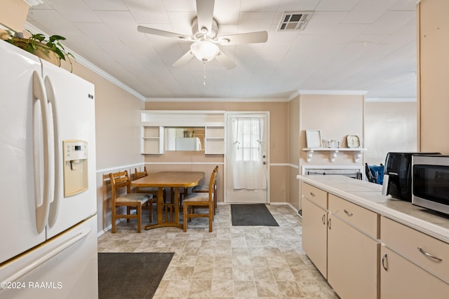 kitchen with crown molding, light tile patterned floors, cream cabinets, ceiling fan, and white refrigerator with ice dispenser