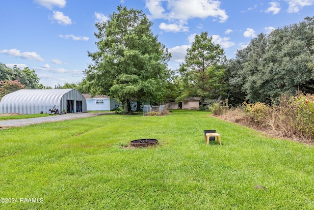 view of yard with an outdoor structure and a fire pit