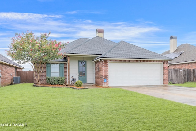 ranch-style house with central air condition unit, a garage, a front lawn, and solar panels