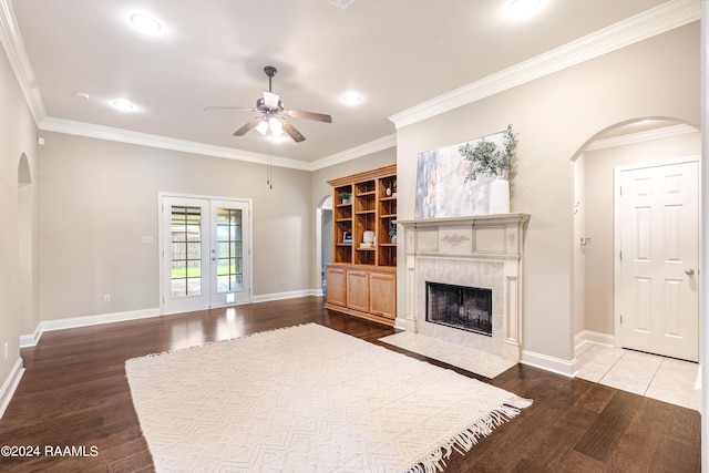 unfurnished living room featuring a tile fireplace, crown molding, and light hardwood / wood-style floors