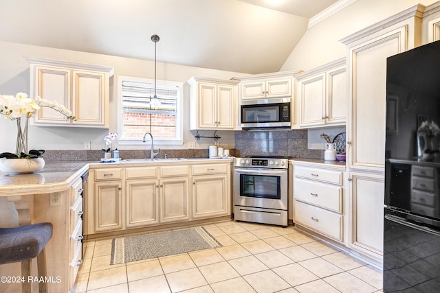 kitchen featuring lofted ceiling, light tile patterned floors, appliances with stainless steel finishes, decorative backsplash, and sink