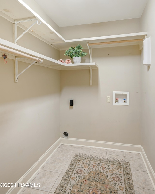 clothes washing area with hookup for an electric dryer, washer hookup, and light tile patterned floors