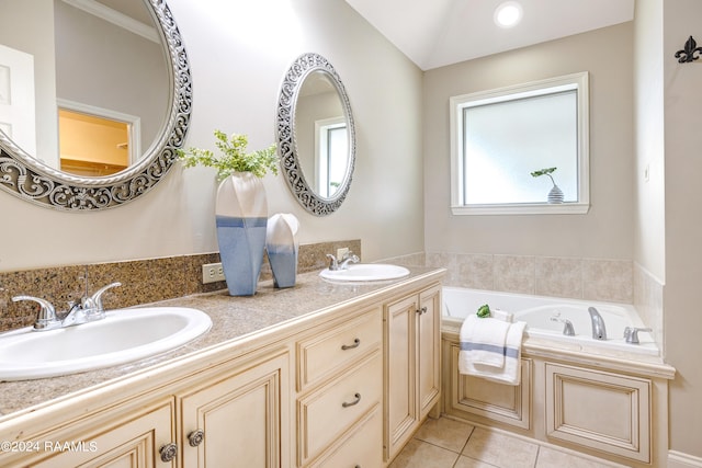 bathroom with tile patterned flooring, a washtub, and dual bowl vanity