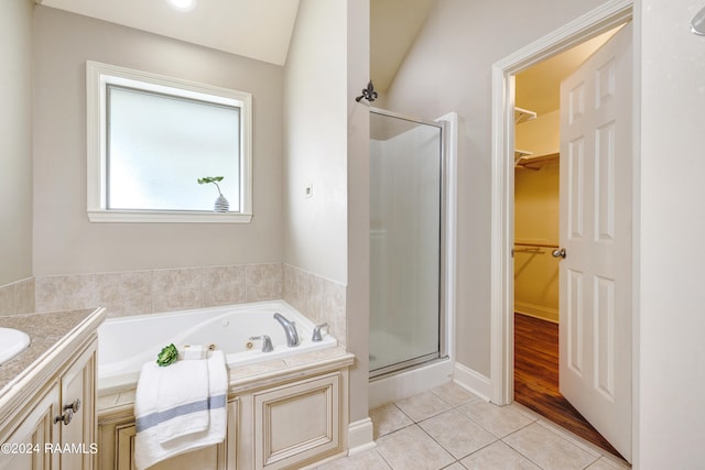 bathroom with vanity, plus walk in shower, hardwood / wood-style flooring, and vaulted ceiling