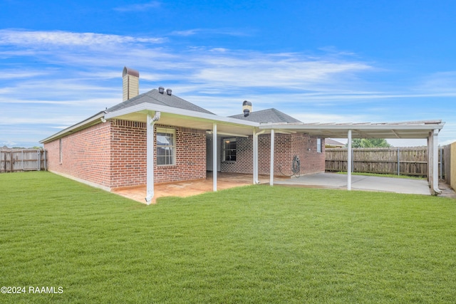 rear view of property with a lawn and a carport