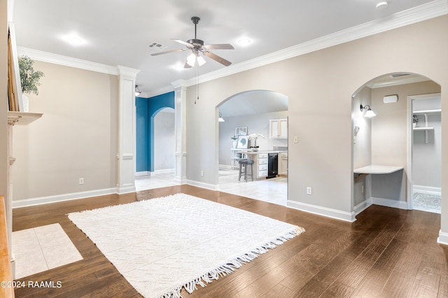 unfurnished living room with ornamental molding, ceiling fan, and light wood-type flooring