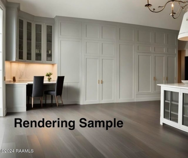 interior space with a breakfast bar, wood-type flooring, gray cabinetry, and an inviting chandelier