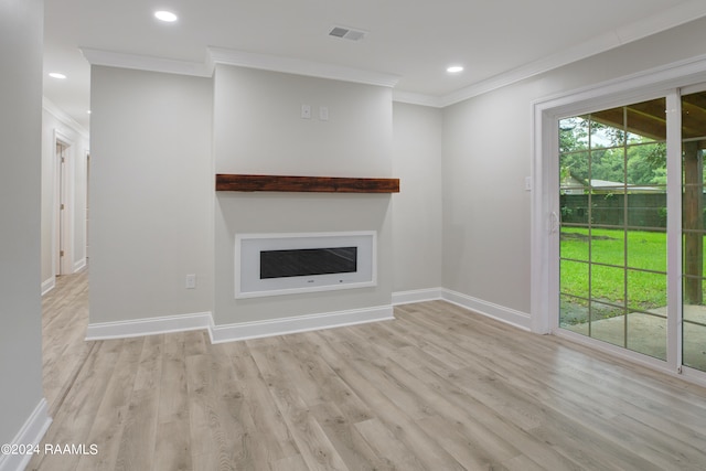 unfurnished living room with ornamental molding and light wood-type flooring