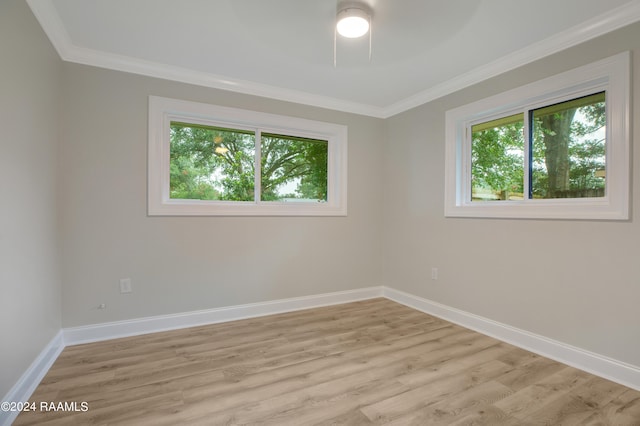 spare room featuring ceiling fan, light hardwood / wood-style flooring, ornamental molding, and plenty of natural light