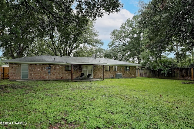 back of property featuring central air condition unit, a patio, and a lawn