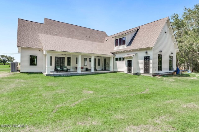 back of property with a patio area and a lawn