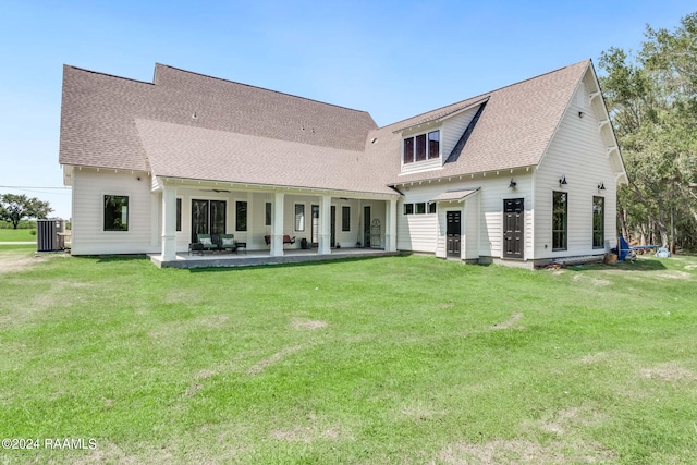 back of property featuring a yard, roof with shingles, and a patio area