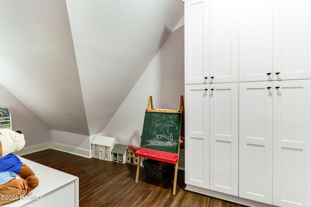 interior space featuring vaulted ceiling, baseboards, and dark wood-style flooring