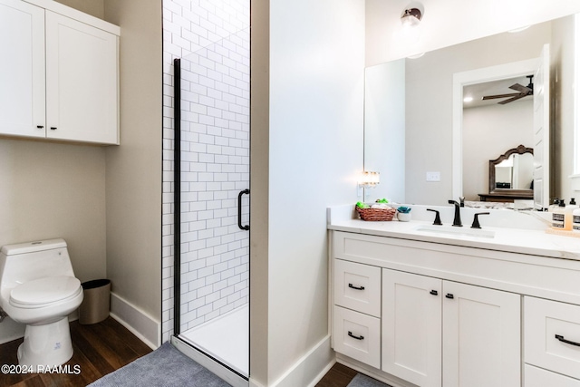 bathroom with wood-type flooring, vanity, an enclosed shower, and toilet